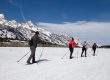 Cross-country skiers traveling on snow-covered Teton Park Road below the Teton Range