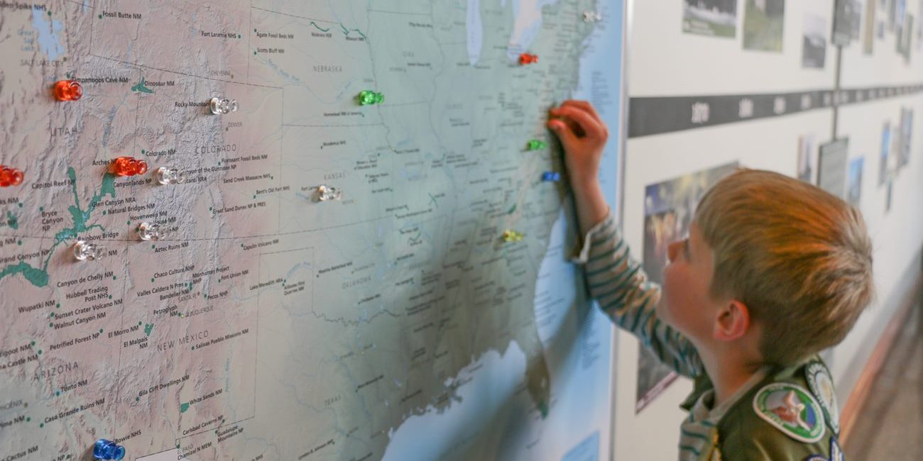 Grand Teton Junior Ranger placing a pin on a national parks map