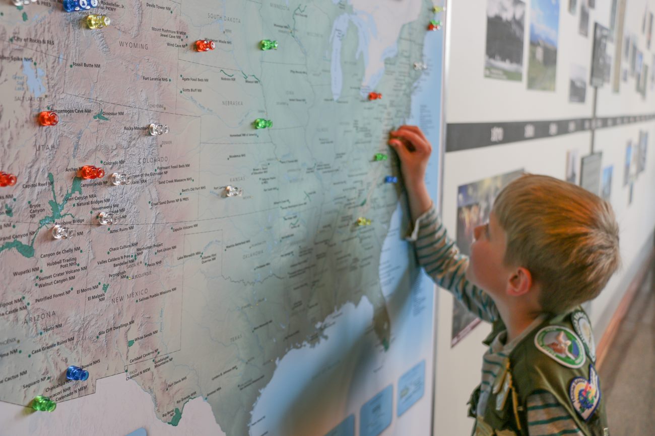 Grand Teton Junior Ranger placing a pin on a national parks map
