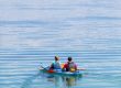 Two visitors resting their paddles in a tandem kayak on Yellowstone Lake