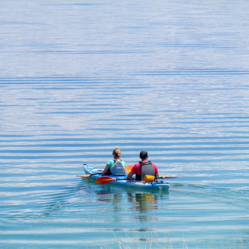 Kayaking or Paddleboarding in Yellowstone: Inspection, Permit and Launch Planning 1 Two visitors resting their paddles in a tandem kayak on Yellowstone Lake